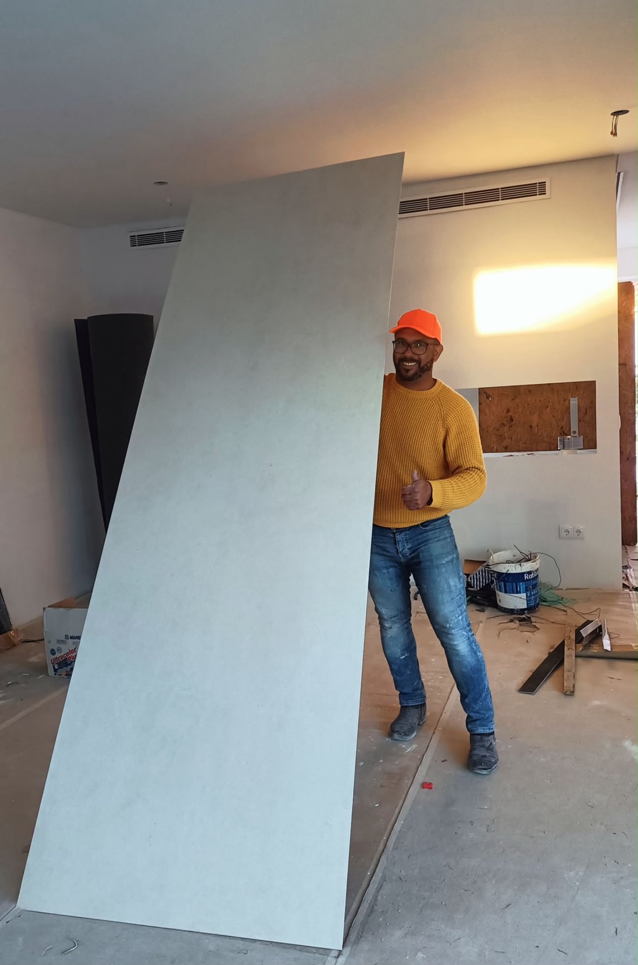 Profissional a transportar placa cerâmica de grande formato em obra